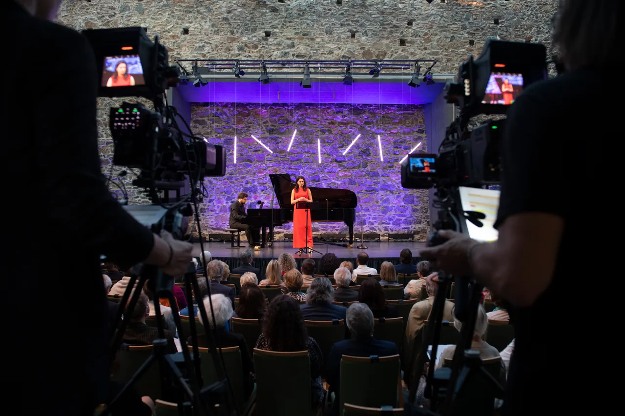 Cámaras de televisión durante la grabación: vista sobre el público hacia el escenario con Asmik Grigorian y Lukas Geniušas