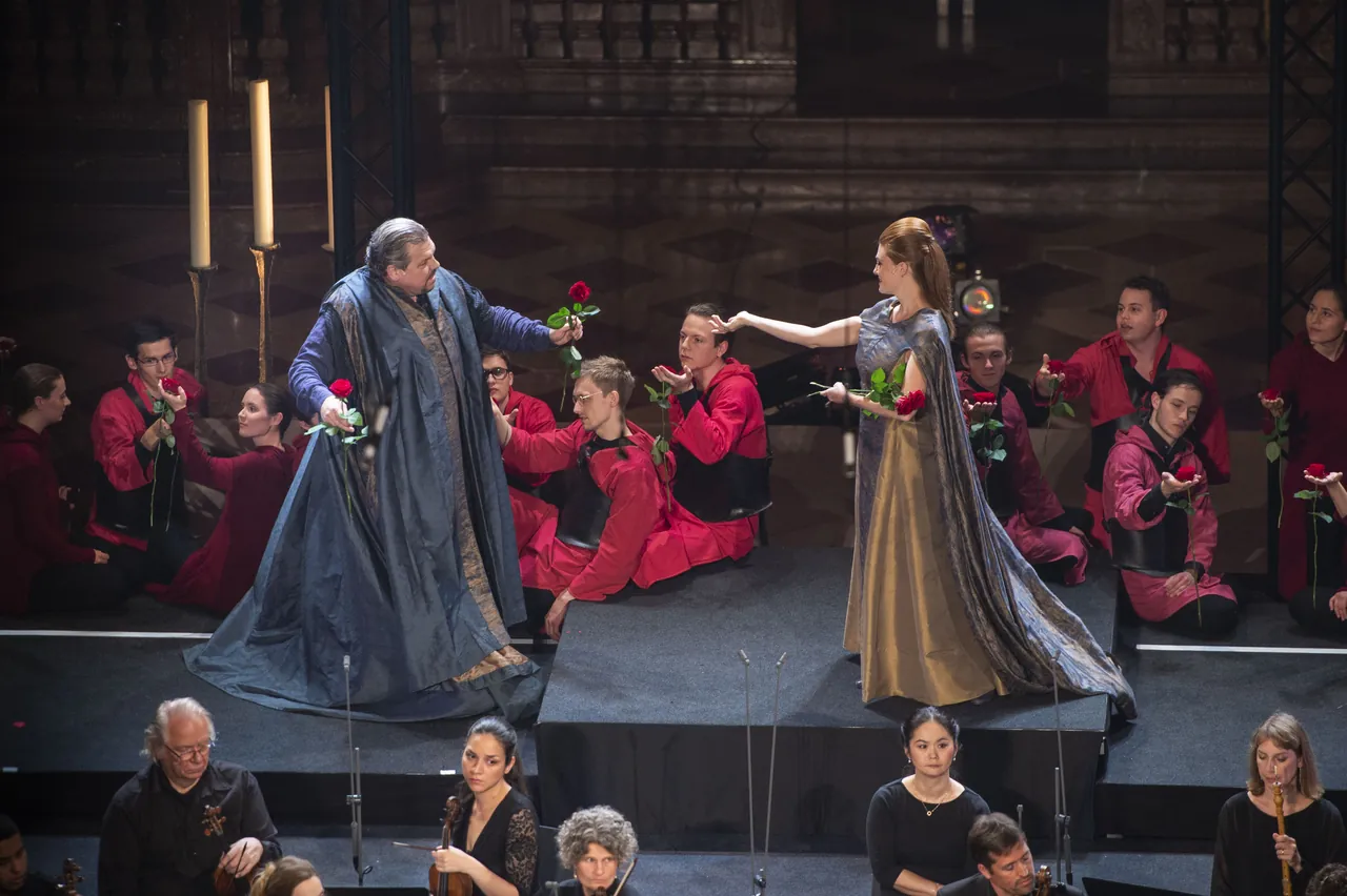 Michael Schade as Aeneas and Wallis Giunta as Dido, surrounded by the choir holding red roses