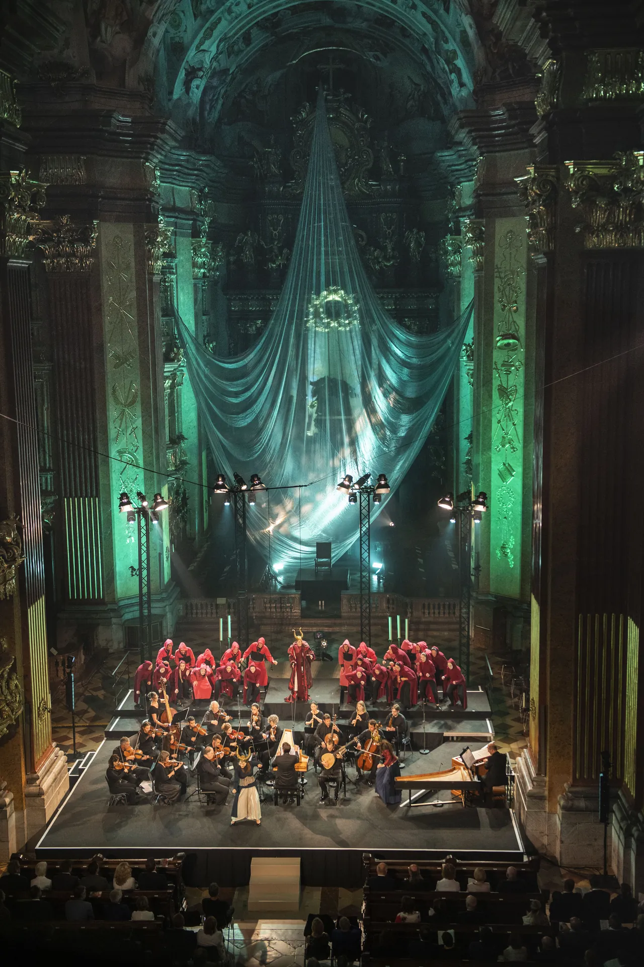 Olivia Vermeulen as the Sorceress in front of choir and orchestra, the stage in green light in the abbey church of Melk