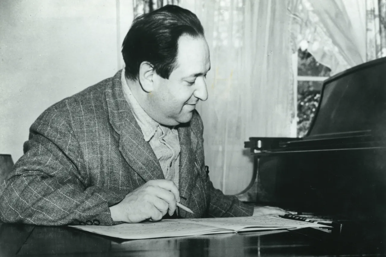 Erich Wolfgang Korngold at the piano with a pencil and a score
