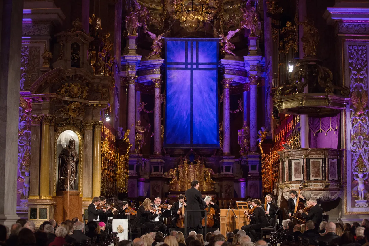 The Bach Consort Wien under Rubén Dubrovsky before the high altar of the abbey church of Klosterneuburg with its blue-lit cross window, the audience in front