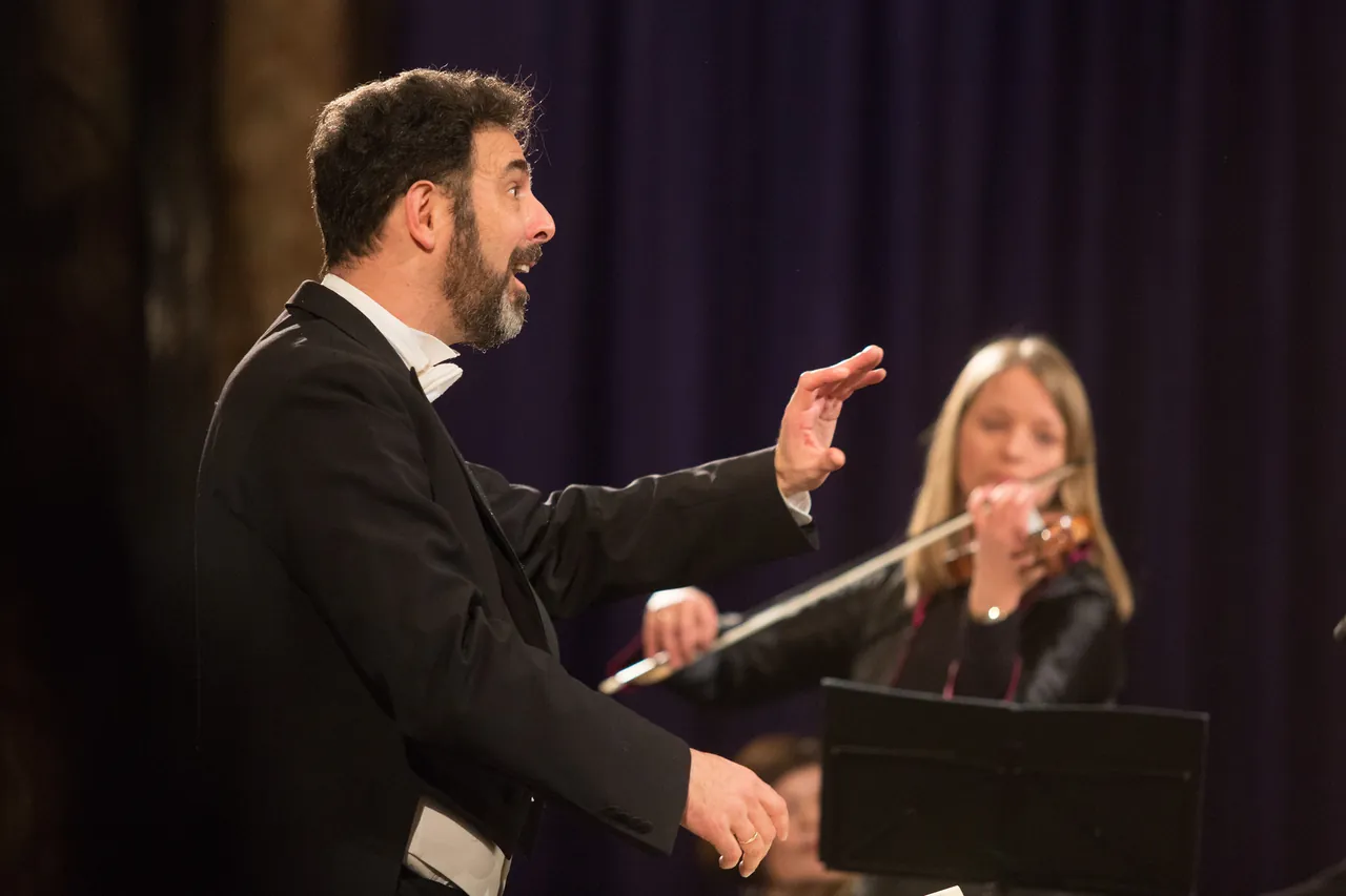 Rubén Dubrovsky conducting, with a violinist behind him