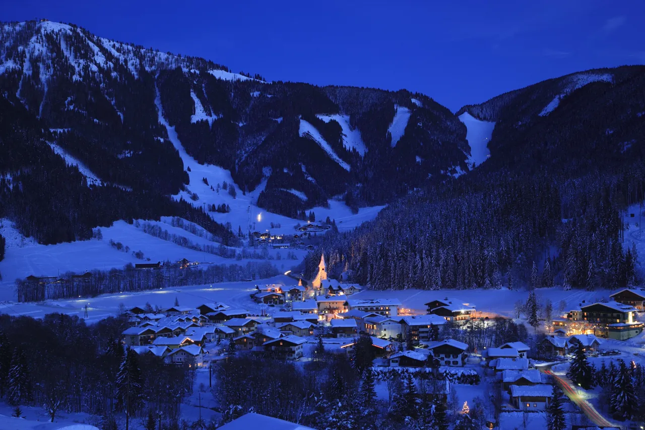 Werfenweng on a winter night, surrounded by snow-covered mountains